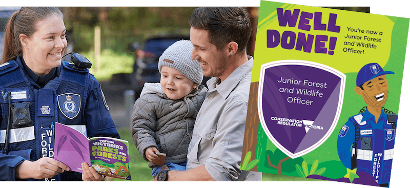 Photo of authorised officer showing Visiting Victoria’s forests and parks activity book to father and young son in park with Junior Forest and Wildlife Officer badge