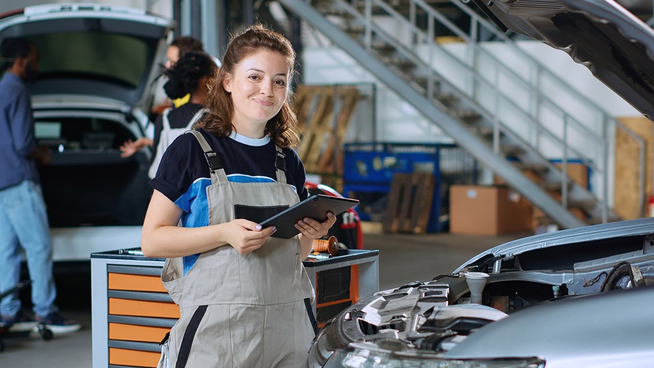 A motor mechanic looking at the camera