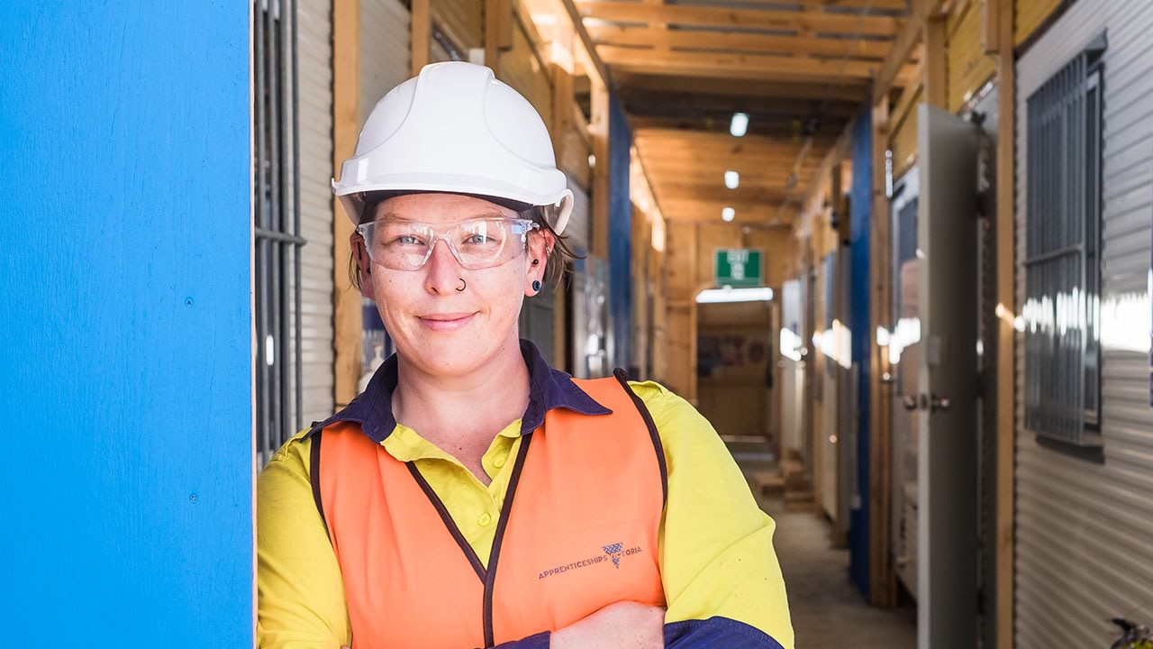 Apprentice leaning on wall in construction setting