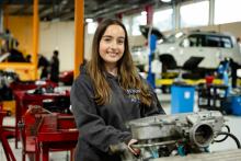 Person smiling in a mechanic workshop