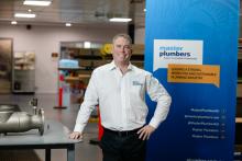 Person standing in a workshop smiling