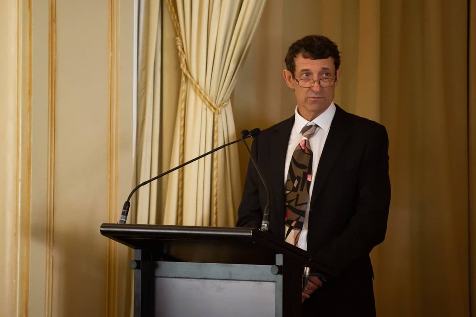 Mr Angus Denton speaks at the lectern. 