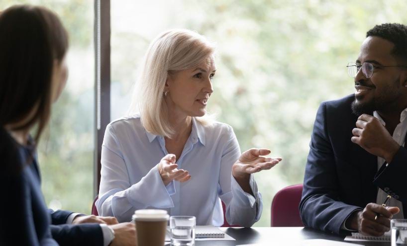 Three people sitting at a meeting room table