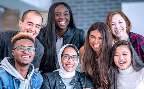 A group of people of different cultural backgrounds smiling