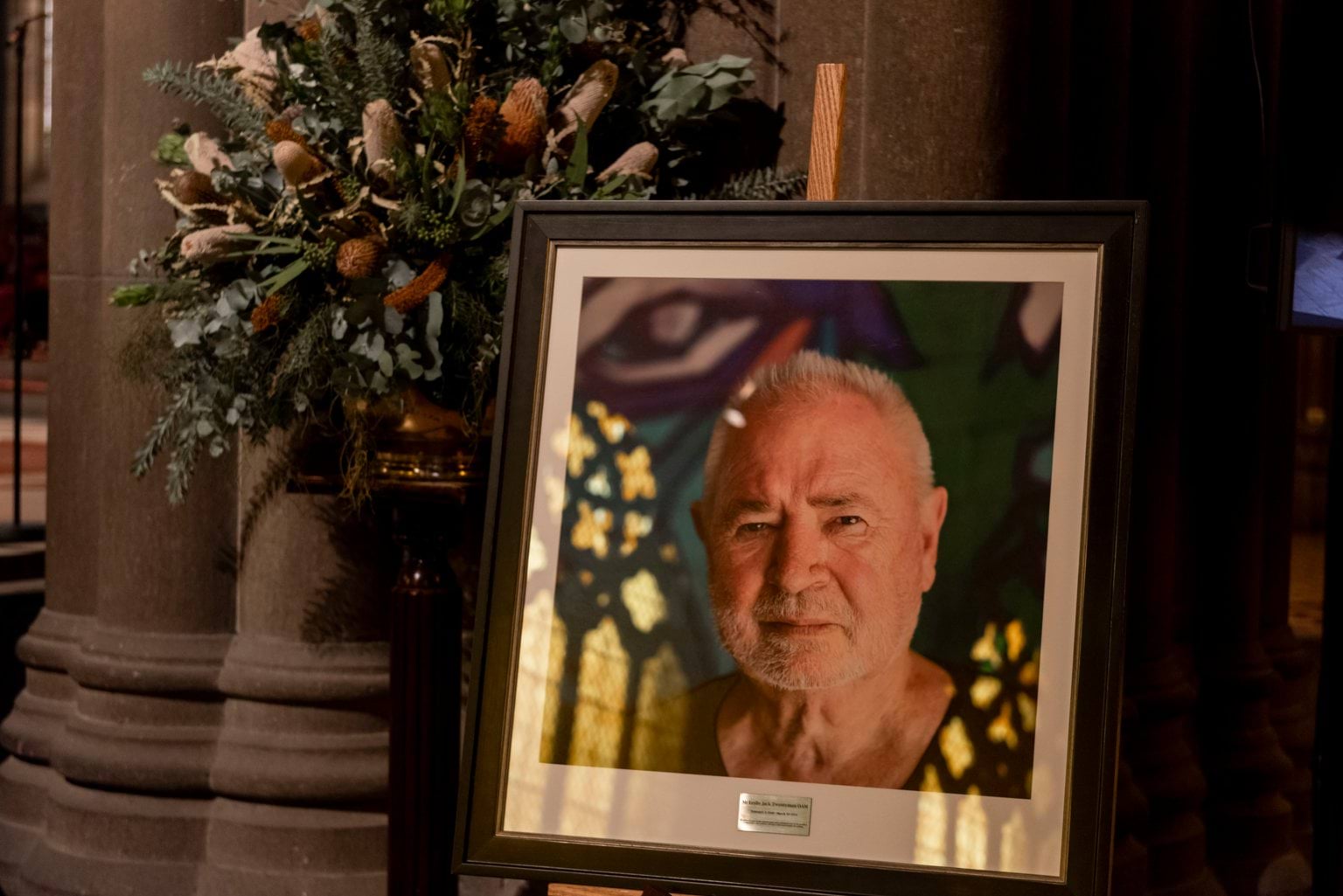 Framed photo of Leslie Twentyman OAM with a bunch of flowers positioned behind.  