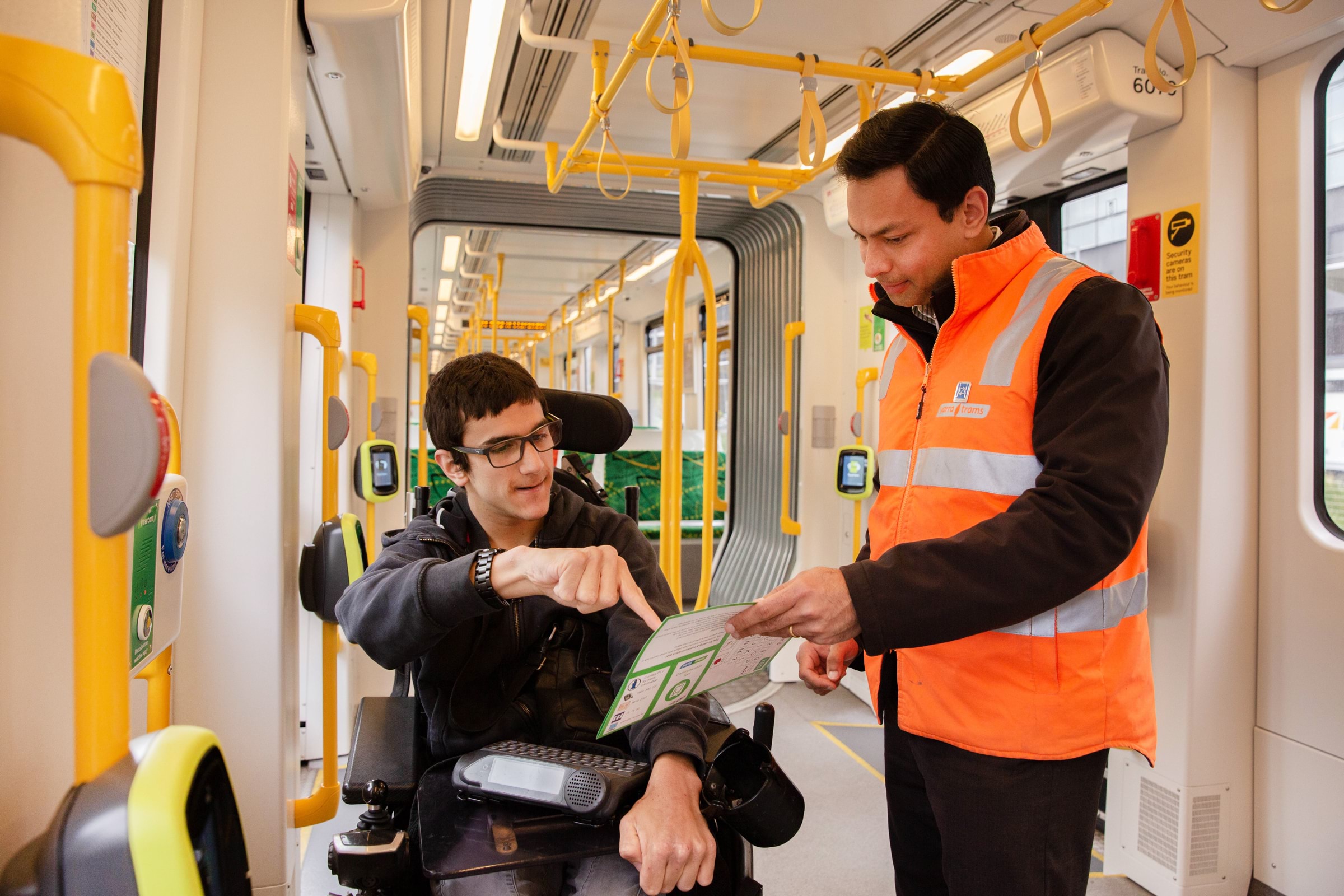 A person pointing at a map with a person in a wheelchair