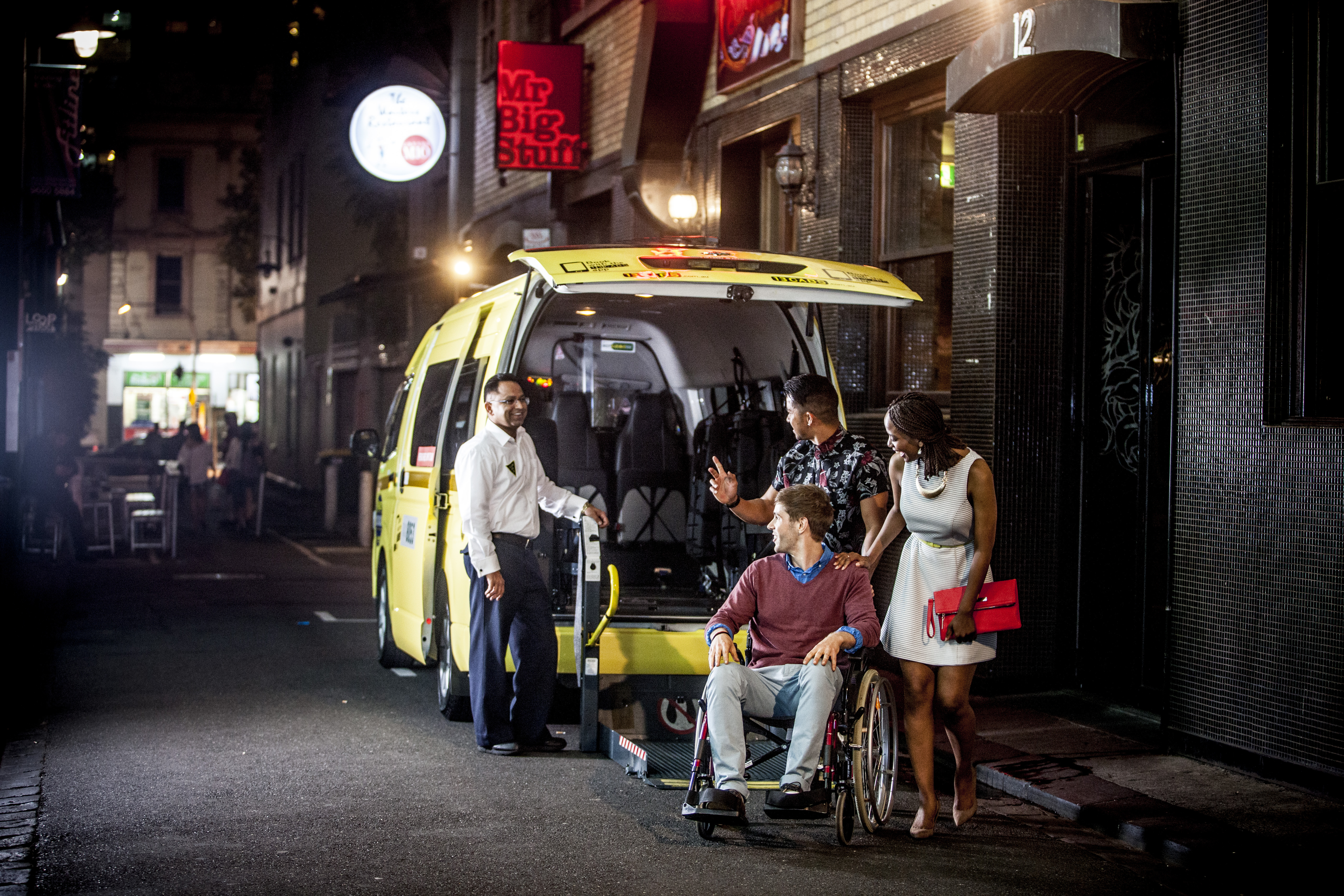 Group of people around an accessible taxi