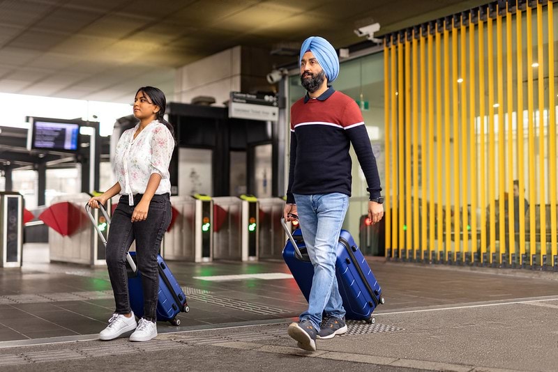 People walking to train station with luggage