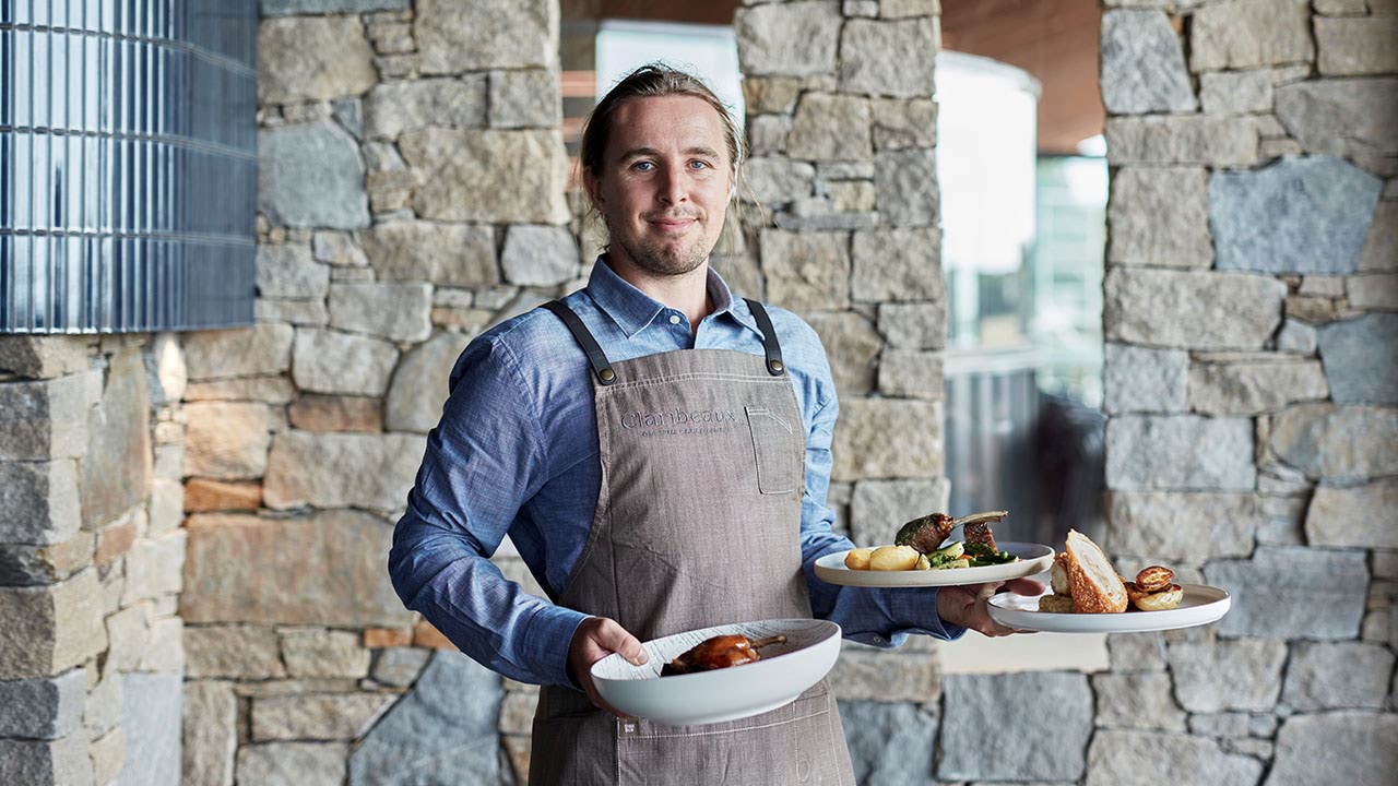 Hospitality worker holding food dishes