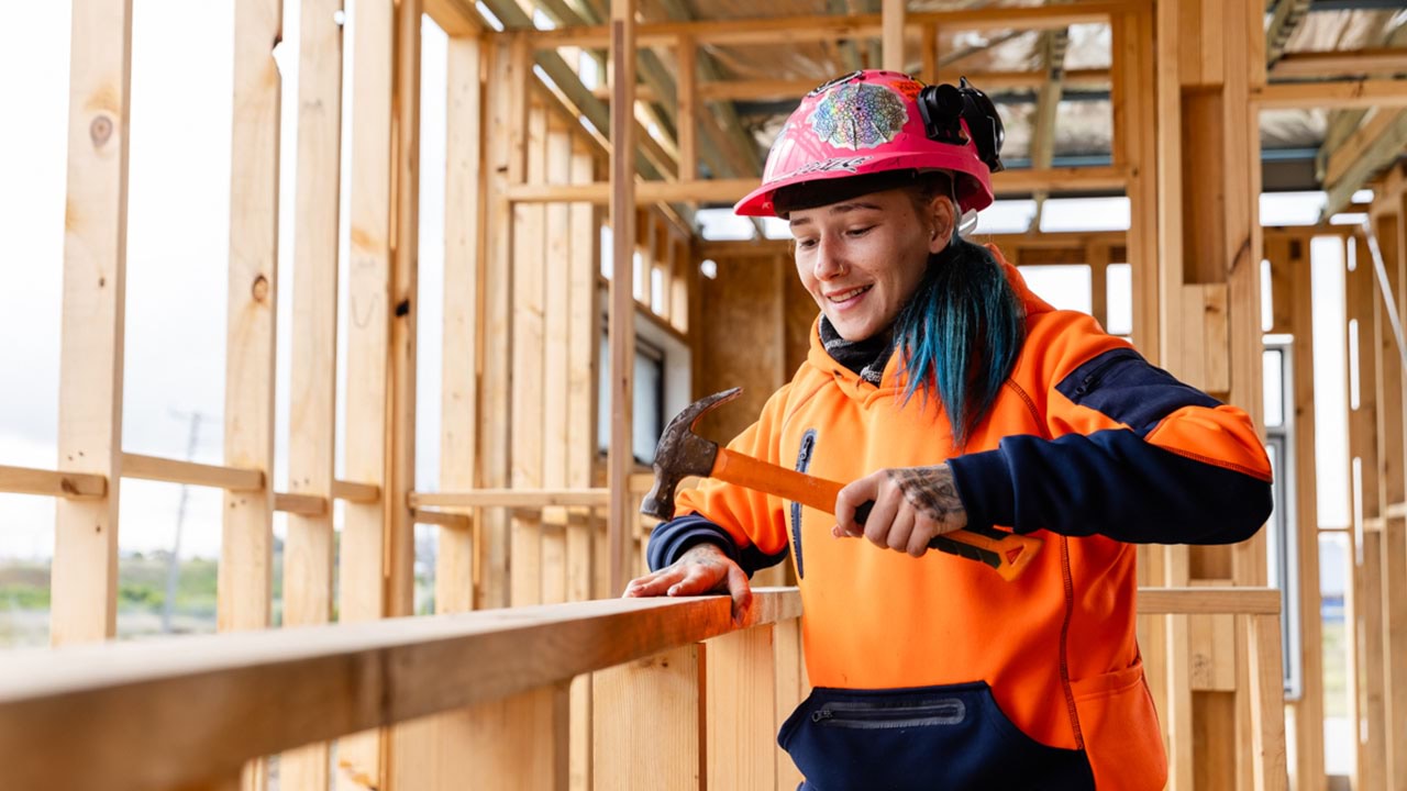 Construction apprentice hammering in a nail