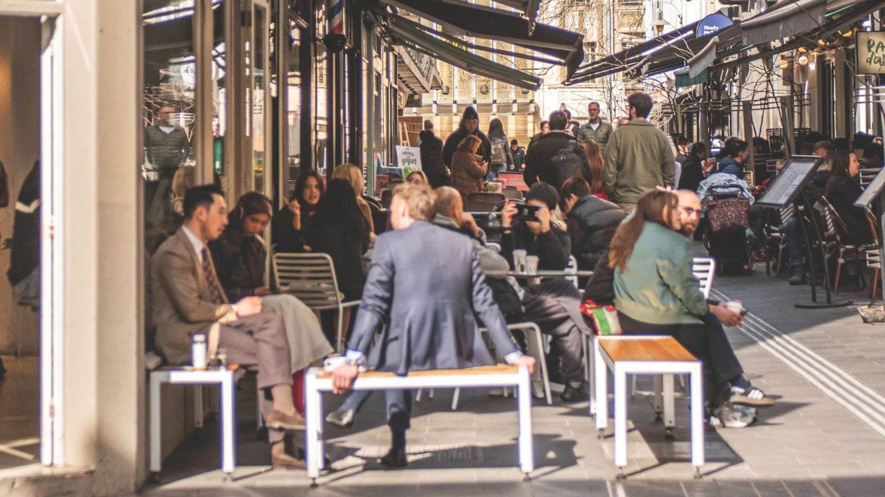 Group of people sitting outside at a busy cafe