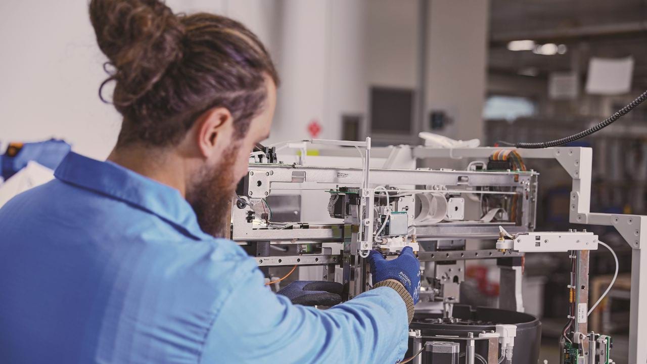 Person working with advanced medical equipment in a lab