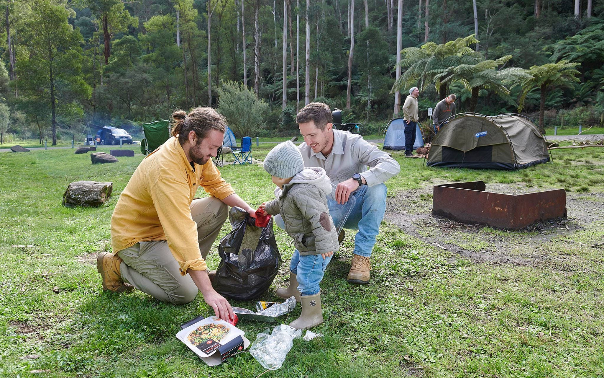 Campers cleaning up rubbish at campsite