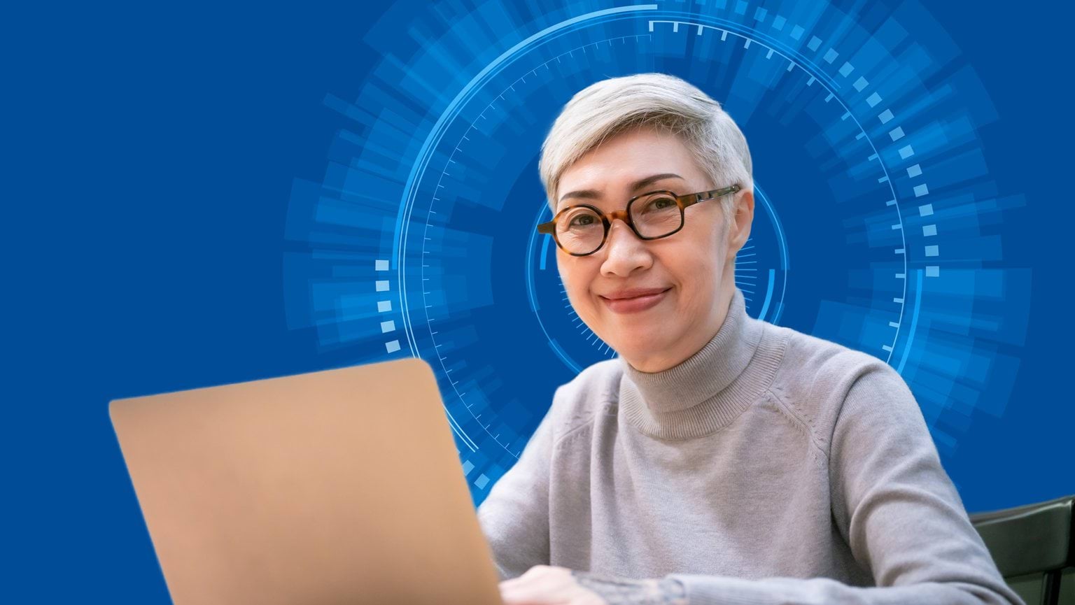 A woman sits at a computer with an tech looking circle motif behind her