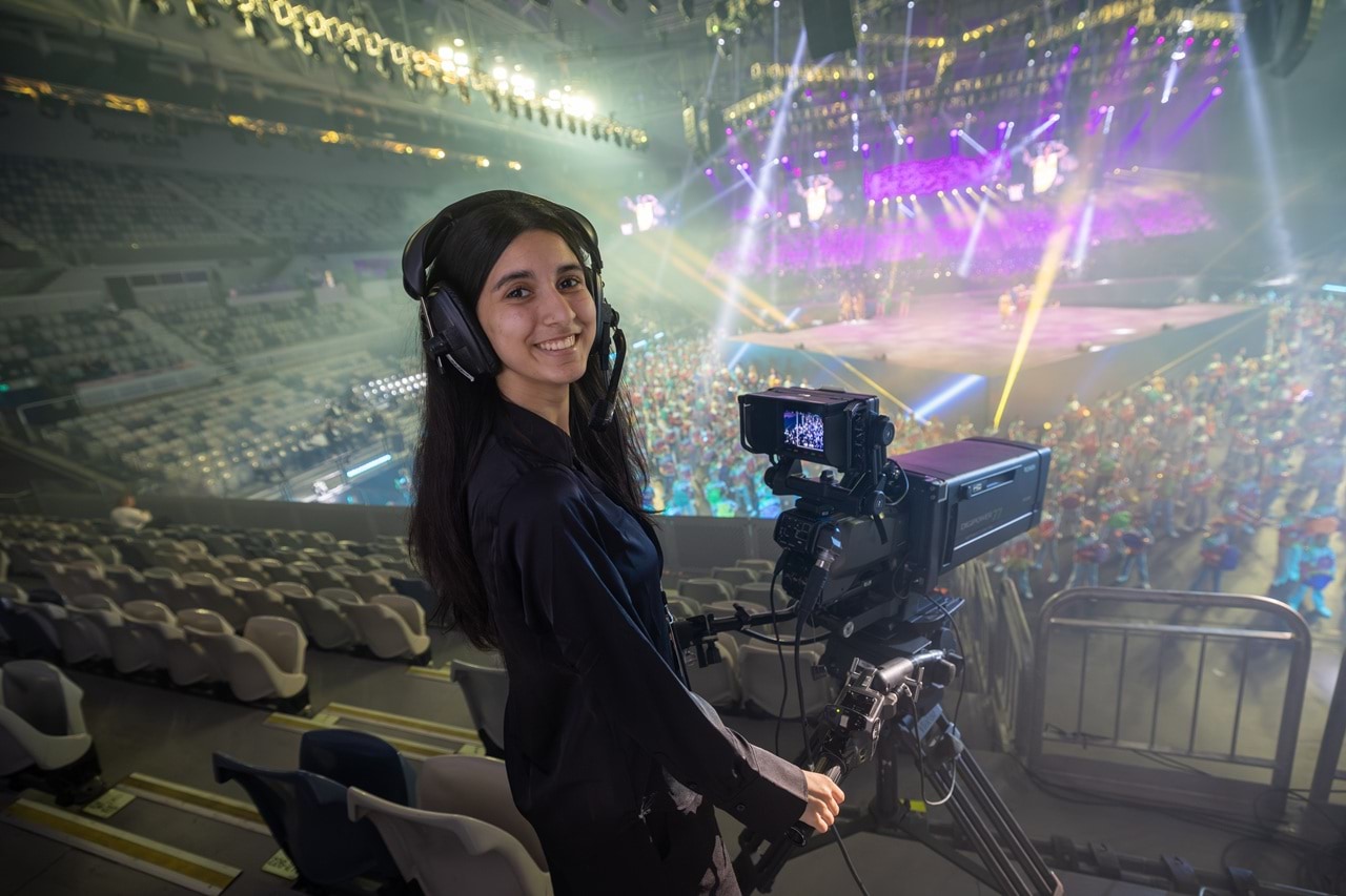 Student using a video recorder in a large auditorium. 