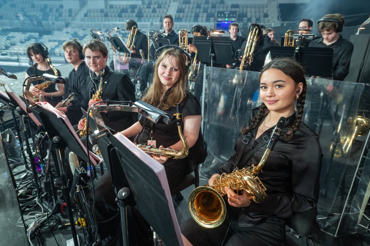 Student orchestra getting reading to play.