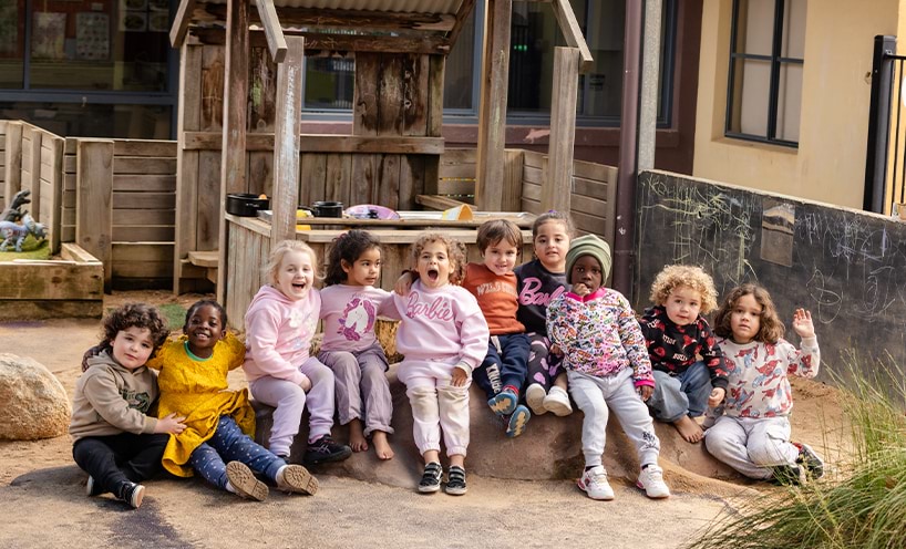 A group of preschoolers sitting in front of a cubby