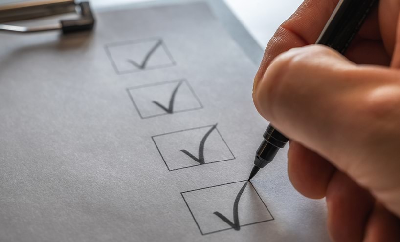 A checklist on a clipboard being ticked off
