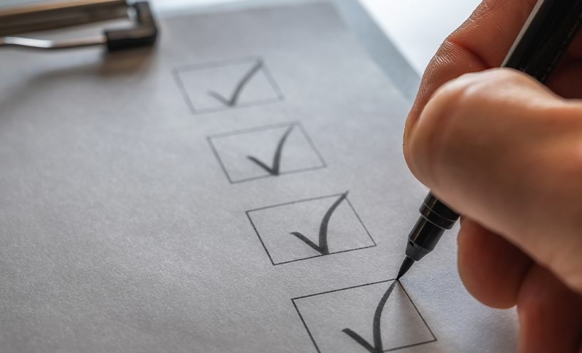 A checklist on a clip board being ticked off