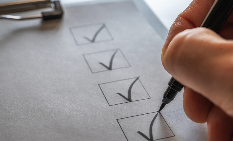 A checklist on a clip board being ticked off